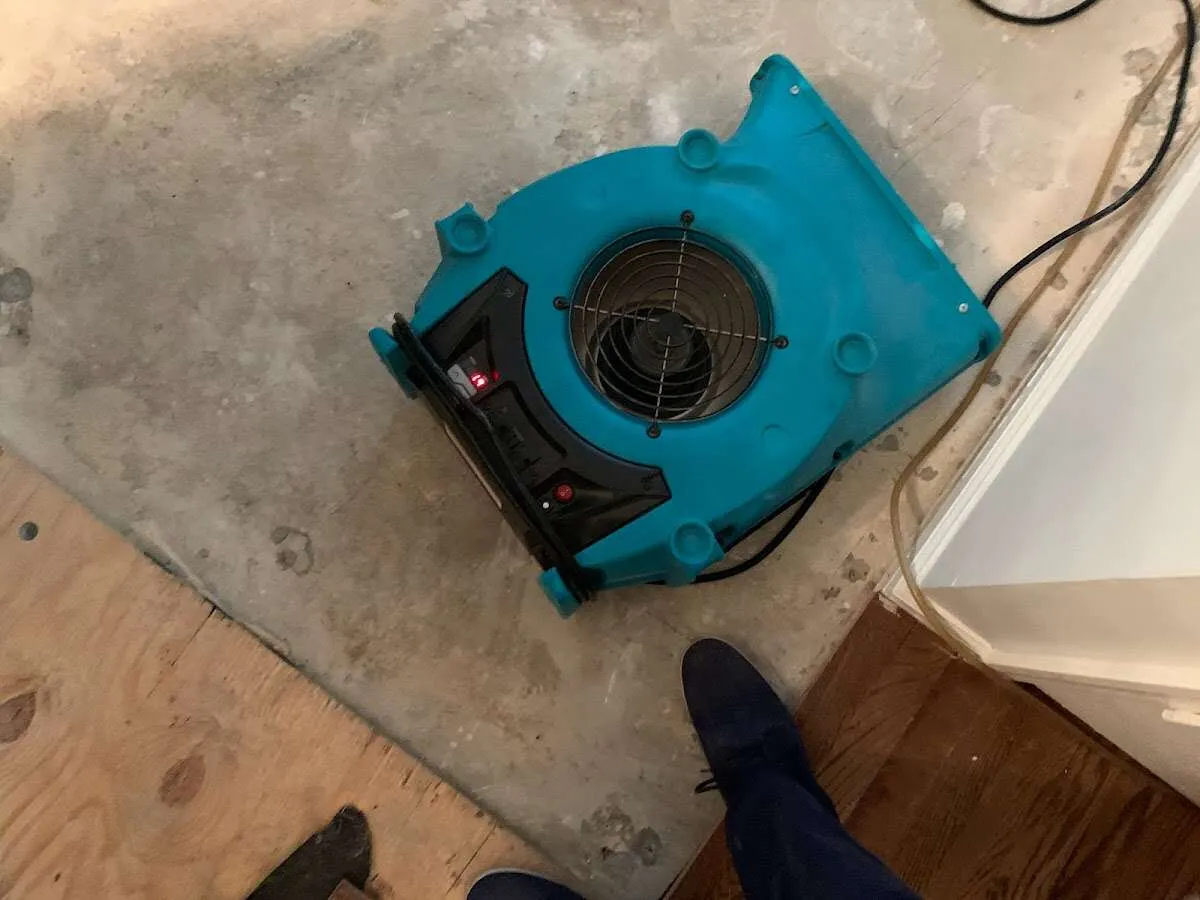 Air mover drying subfloor during Commercial Water Damage Restoration in St. Albans